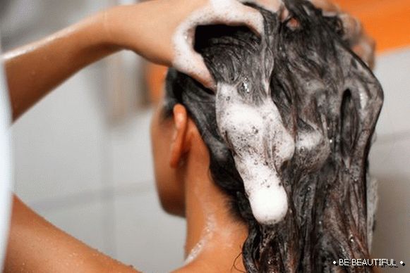 момичето измива косата си с шампоан